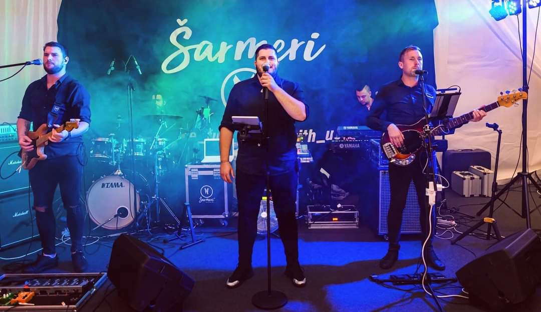 Šarmeri bend na pozornici s plavim osvjetljenjem - live nastup